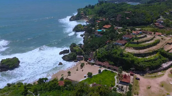 Beyaz kum, mercan kayaları, ağaçlı tepeler, Mbuluk Plajı Gunung Kidul Yogyakarta olarak bilinen okyanustan gelen dalgalar...