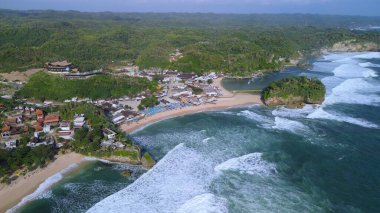 Kumsalın beyaz kum, mercan kayaları, ağaçlı tepeler, Drini Sahili Gunung Kidul Yogyakarta olarak bilinen okyanustan gelen dalgalar...