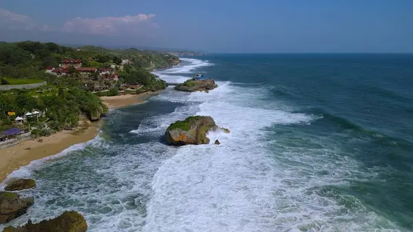 Beyaz kum, mercan kayaları, ağaçlı tepeler, Mesra Sahili Gunung Kidul Yogyakarta olarak bilinen okyanustan gelen dalgalar...