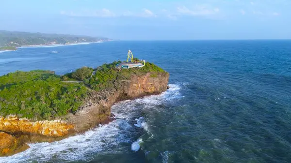 Beyaz kum, mercan kayaları, ağaçlı tepeler, Krakal Sahili Gunung Kidul Yogyakarta olarak bilinen okyanustan gelen dalgalar ile sahilin insansız hava aracı görüntüsü.
