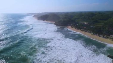 Beyaz kumlu plajlar, mercan kayaları, ağaçlı tepeler, okyanustan gelen büyük dalgalar ve Drini Sahili Gunung Kidul Yogyakarta olarak da bilinen akıntılar.