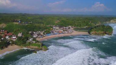 Beyaz kumlu plajlar, mercan kayaları, ağaçlı tepeler, okyanustan gelen büyük dalgalar ve Drini Sahili Gunung Kidul Yogyakarta olarak da bilinen akıntılar.