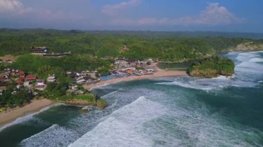 Beyaz kumlu plajlar, mercan kayaları, ağaçlı tepeler, okyanustan gelen büyük dalgalar ve Drini Sahili Gunung Kidul Yogyakarta olarak da bilinen akıntılar.