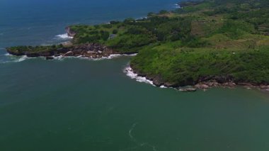 Baron Sahili, Gunung Kidul, Yogyakarta 'da turist ve geleneksel balıkçı limanı olan mercan tepeli dalgalar.