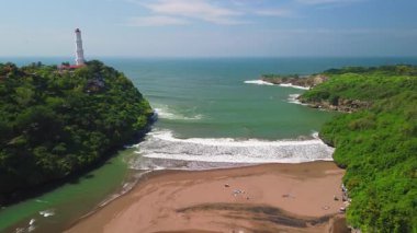 Hava aracı görüntüsü Deniz feneri ya da Baron sahilindeki mercan tepesi, Gunung Kidul, Yogyakarta, aynı zamanda bir turizm ve geleneksel balıkçılık limanı.