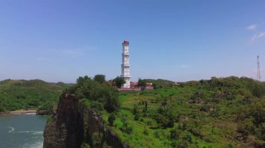 Hava aracı görüntüsü Deniz feneri ya da Baron sahilindeki mercan tepesi, Gunung Kidul, Yogyakarta, aynı zamanda bir turizm ve geleneksel balıkçılık limanı.