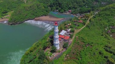 Hava aracı görüntüsü Deniz feneri ya da Baron sahilindeki mercan tepesi, Gunung Kidul, Yogyakarta, aynı zamanda bir turizm ve geleneksel balıkçılık limanı.