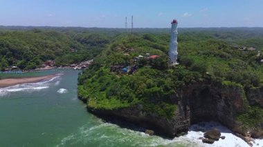 Hava aracı görüntüsü Deniz feneri ya da Baron sahilindeki mercan tepesi, Gunung Kidul, Yogyakarta, aynı zamanda bir turizm ve geleneksel balıkçılık limanı.