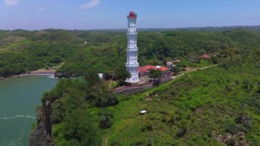 Hava aracı görüntüsü Deniz feneri ya da Baron sahilindeki mercan tepesi, Gunung Kidul, Yogyakarta, aynı zamanda bir turizm ve geleneksel balıkçılık limanı.