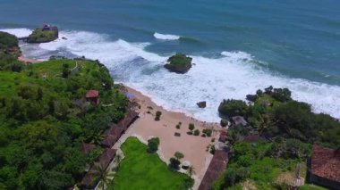 Mesra Sahili 'nin insansız hava aracı görüntüsü Gunung Kidul Yogyakarta tepeleri, beyaz kumları, mercan kayalıkları ve ünlü bir turizm merkezi olan okyanus dalgalarıyla dolu bir plaj.