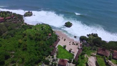 Mesra Sahili 'nin insansız hava aracı görüntüsü Gunung Kidul Yogyakarta tepeleri, beyaz kumları, mercan kayalıkları ve ünlü bir turizm merkezi olan okyanus dalgalarıyla dolu bir plaj.