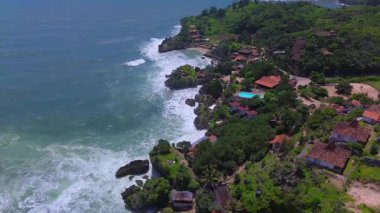 Mesra Sahili 'nin insansız hava aracı görüntüsü Gunung Kidul Yogyakarta tepeleri, beyaz kumları, mercan kayalıkları ve ünlü bir turizm merkezi olan okyanus dalgalarıyla dolu bir plaj.