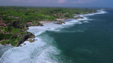 Mbuluk Sahili ve Kukup Sahili 'nin yanındaki Mesra Sahili' nin insansız hava aracı manzarası Gunung Kidul Yogyakarta, tepeleri, beyaz kumları, mercan kayalıkları ve okyanus dalgaları olan ünlü bir turizm beldesi.