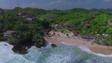 Mesra Sahili 'nin insansız hava aracı görüntüsü Gunung Kidul Yogyakarta tepeleri, beyaz kumları, mercan kayalıkları ve ünlü bir turizm merkezi olan okyanus dalgalarıyla dolu bir plaj.