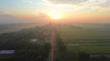 Hava aracı görüntüsü dramatik gün doğumu ve sabah altın saati, tarımsal arazisi olan kırsal bir alanda, ortada bir otoyol ve nehri geçen bir köprü ile.
