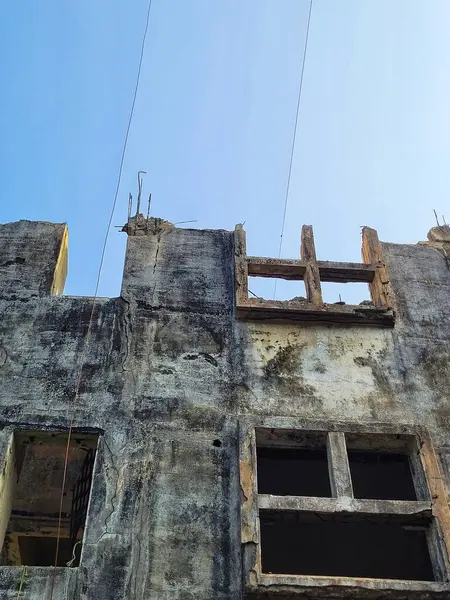 Güneşli bir günde, açık mavi gökyüzünün altındaki terk edilmiş bir binanın altından.