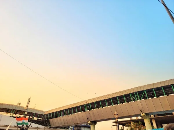 Mumbai 'de gün batımında, turuncu gökyüzünün altındaki tren istasyonunun dışında gökyüzünün altından.