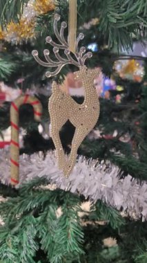 Gündüz vakti bir alışveriş merkezindeki Noel ağacında asılı duran süs resmi.