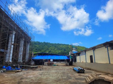 Gündüz vakti mavi gökyüzünün altında inşaat iskelesi olan binanın dış cephesi.