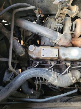 Paslanmış metal parçaları ve karmaşık bileşenleri gösteren eski bir araba motorunun yakınlaştırılması.