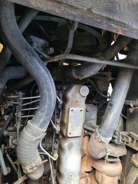 Paslanmış metal parçaları ve karmaşık bileşenleri gösteren eski bir araba motorunun yakınlaştırılması.