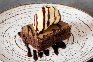 plate with a chocolate brownie and vanilla ice cream