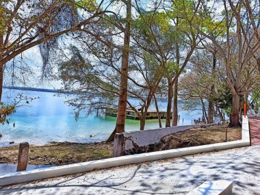 Abandoned house on Lake Peten Itza surrounded by lush vegetation in San Andres, Peten clipart