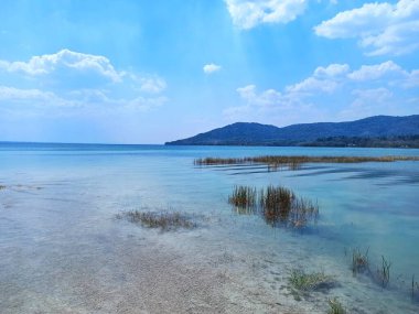 Peten Itza Gölü 'nün berrak suları ve manzarası El Remate, Peten, Guatemala