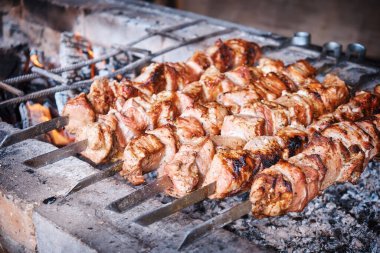 Terbiye edilmiş şiş kebap mangal ızgarasında hazırlanır. Yakın plan.