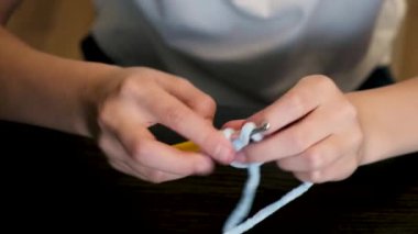 Close-up of girls hands starting to crochet to make knitted creations.