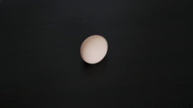 A chicken egg rotates around its axis. Close-up