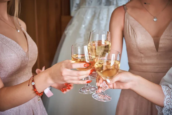 The bride and her friends drink wine and cheer each other on. Wedding theme.