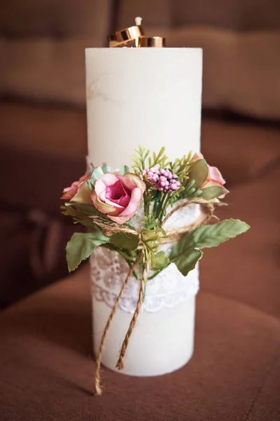 A beautiful wedding composition of a candle and wedding rings.