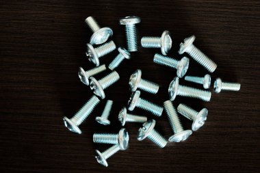 Koyu arkaplanda izole edilmiş farklı cıvatalar kümesi.