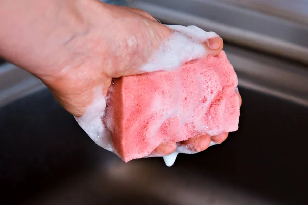 Homem Segura Uma Esponja Cozinha Vermelha Sua Mão Que Espumada — Fotografia de Stock