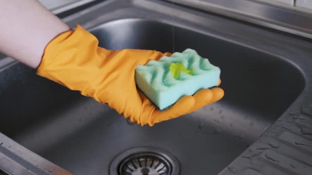 一个人的手拿着厨房的海绵 把洗碗液倒在海绵上 然后用肥皂擦拭 厨房的主题 后续行动 — 图库视频影像