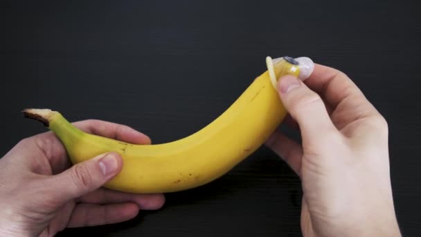 Ένα Προφυλακτικό Απλώνεται Πάνω Από Μια Μπανάνα Έννοια Του Ασφαλούς — Αρχείο Βίντεο