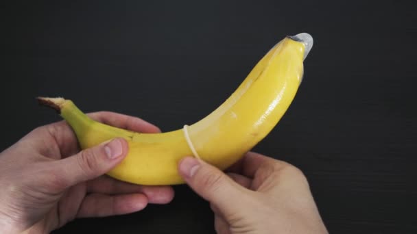 Mężczyzna Próbuje Ostrożnie Usunąć Prezerwatywę Banana Koncepcja Bezpiecznego Seksu Zapobieganie — Wideo stockowe