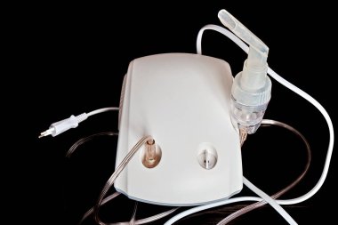 Solunum tüpü ile solunum için tıbbi ekipman. Nebulizör koyu bir arkaplanda izole edilmiş. Solunum astımının tedavisi için. Bronşit tedavisi için ekipman.