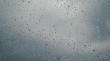 Close-up of water drops on glass, rain. Large drops of rain hit the window during a downpour. 4K video.