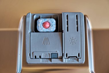 Tablet bulaşık makinesi kapısının içindeki deterjanlar için bölmede bulunuyor. Yukarıdan görüntüle.