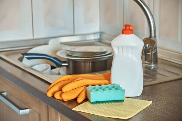 A set for washing dishes, a kitchen foam sponge, protective gloves and a bottle of detergent