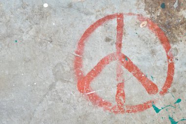 Üzerinde lekeler olan beton bir duvar ve uluslararası barış, silahsızlanma, savaş karşıtı ve nükleer karşıtı hareketin sembolü olan kırmızı bir işaret..
