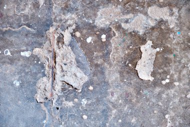 Gri beton bir duvar. Çeliğin görülebildiği göçükler var. Doku, arkaplan.