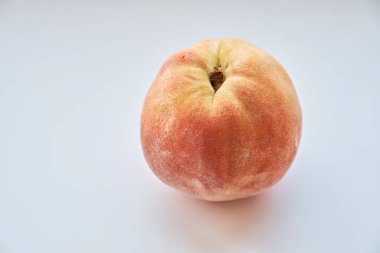 Beyaz arkaplanda bir şeftalinin yakın çekimi.