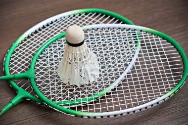Mekik siki iki badminton raketine dayanıyor. Profesyonel spor ekipmanları.
