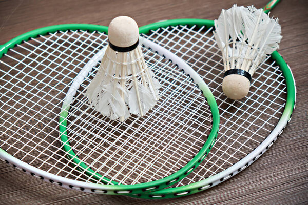 Two shuttlecocks lie on badminton rackets. Professional sports equipment.