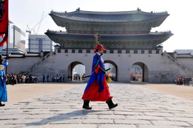 SEOUL, SOUTH KOREA - OCTOBER 27, 2022: Korean ancient old soldier warriors guard changing event among many tourists in Gyeongbokgung Palace front ground. clipart