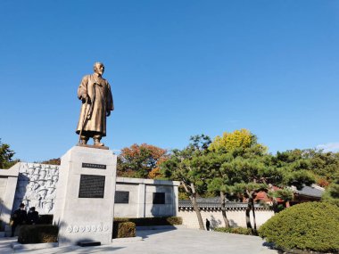 SEOUL, Güney Kore - 25 Ekim 2022: Sonbahar mevsiminde bir bahçede Koreli kahraman öğretim üyesi ve akademisyen anıtı. Olay yerinde 2 subay ve 1 turist var..