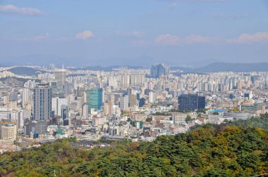 SEOUL, Güney Kore - 23 Ekim 2022: Seul 'deki yüksek binaların ve apartmanların gökdelen manzarası öğleden sonra Namsan dağlarını gözetliyor